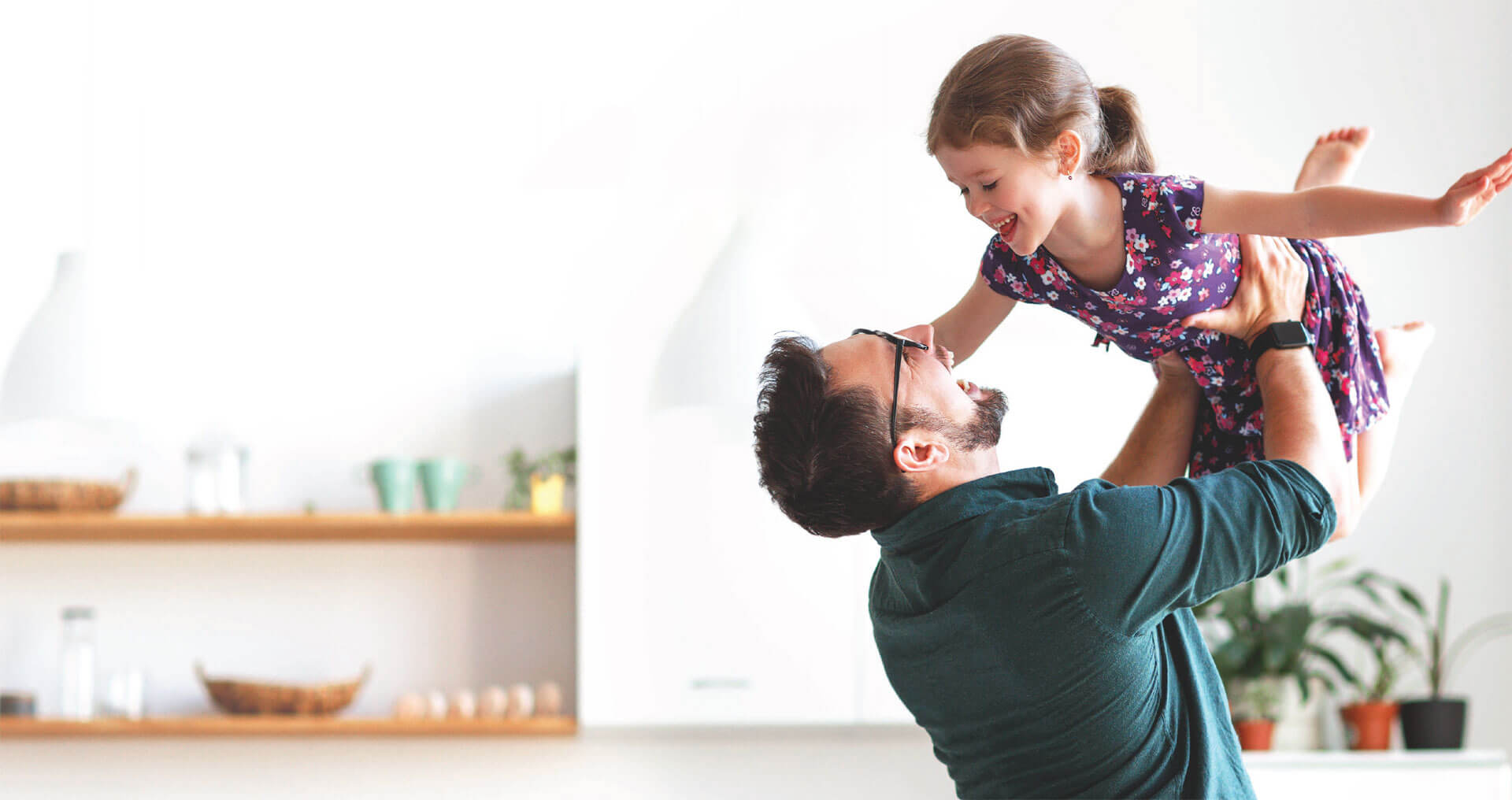 man lifting up child in a smart home
